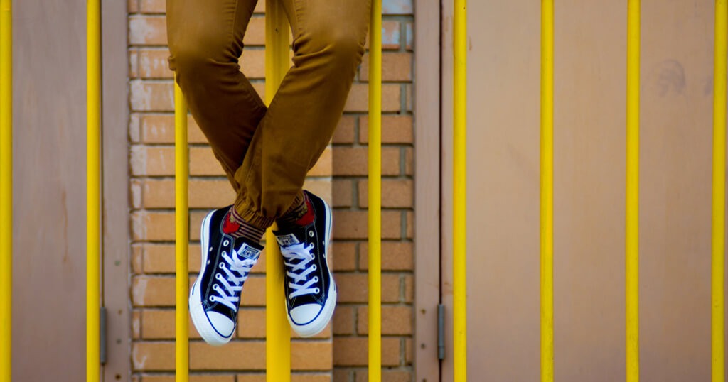 teenager sitting on top of rails